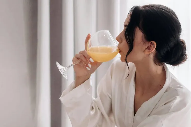 Žena pije sok od narandze